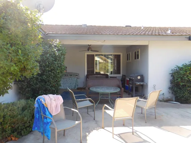 a view of a patio with table and chairs with wooden fence