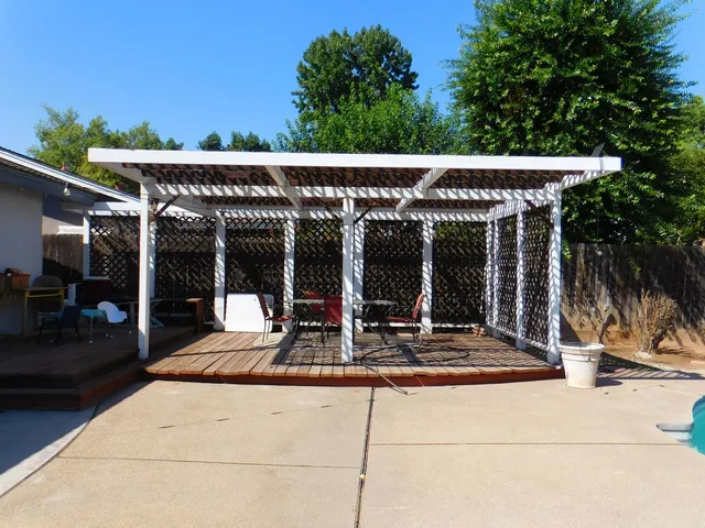 a view of the patio with table and chairs potted plants and floor to ceiling window