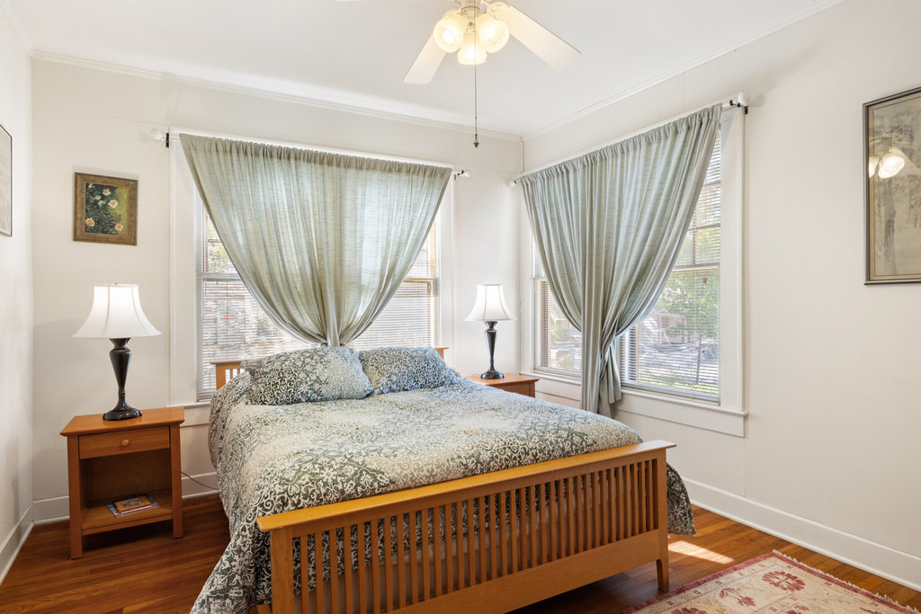 1609 Wethersfield Road Austin, TX 78703 - Photo 14 of 38 Bedroom featuring dark wood-type flooring, multiple windows, ceiling fan, and crown molding