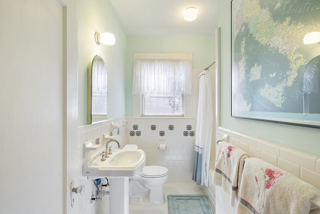1609 Wethersfield Road Austin, TX 78703 - Photo 15 of 38 Full bathroom featuring tile walls, wainscoting, and shower / tub combo with curtain
