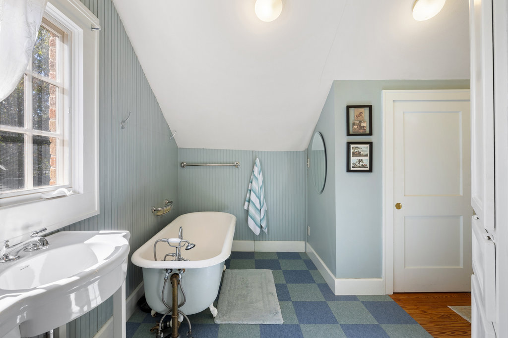 1609 Wethersfield Road Austin, TX 78703 - Photo 20 of 38 Full bathroom with dark flooring, a freestanding tub, healthy amount of natural light, and vaulted ceiling