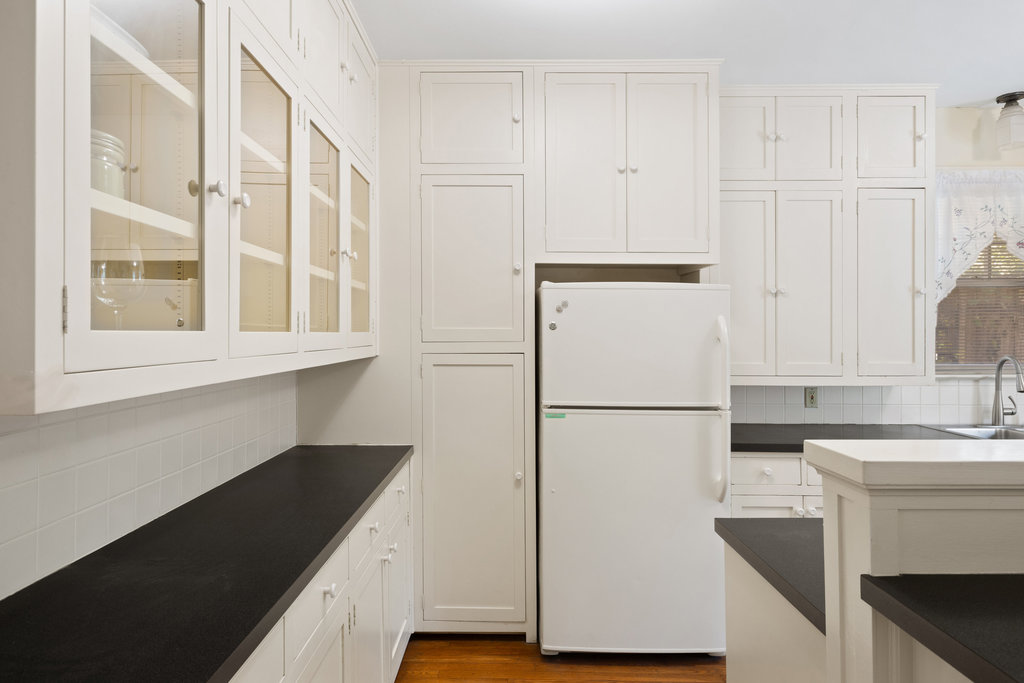 1609 Wethersfield Road Austin, TX 78703 - Photo 10 of 38 Kitchen with dark countertops, backsplash, freestanding refrigerator, white cabinetry, and glass insert cabinets