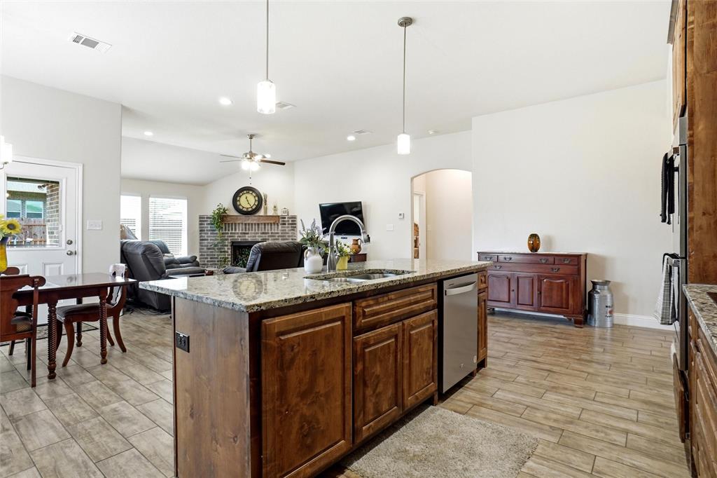 904 Avagail Avenue Springtown, TX 76082 - Photo 11 of 27 a large kitchen with kitchen island a stove a sink a dining table and chairs