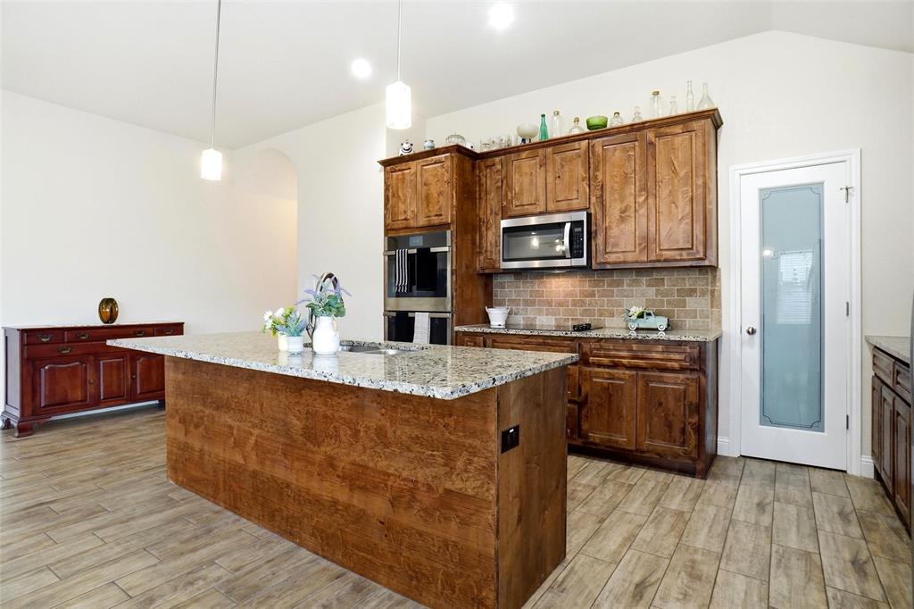 904 Avagail Avenue Springtown, TX 76082 - Photo 13 of 27 a kitchen with stainless steel appliances granite countertop a stove a sink and a refrigerator