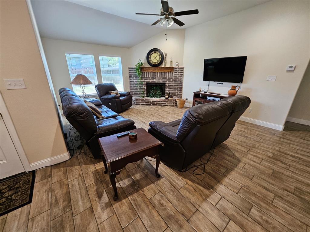 904 Avagail Avenue Springtown, TX 76082 - Photo 8 of 27 a living room with furniture a fireplace and a flat screen tv