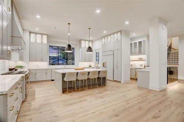 a large kitchen with stainless steel appliances kitchen island granite countertop a large island a stove a refrigerator and a sink