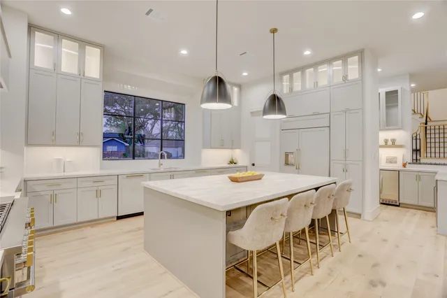 a kitchen with cabinets and chairs
