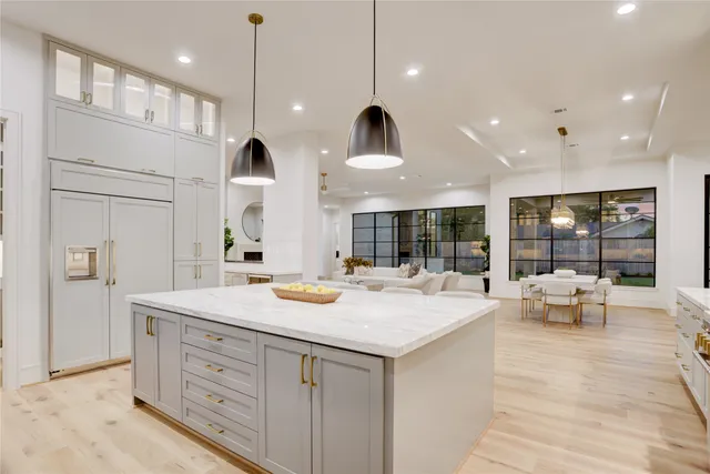 a large kitchen with kitchen island a large island in it