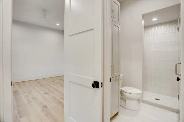 a bathroom with a granite countertop toilet a sink and shower