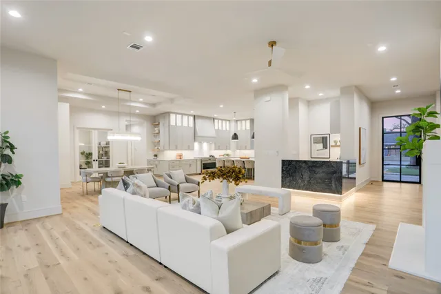 a living room with furniture and a view of kitchen
