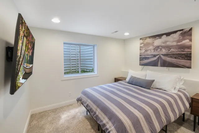 a bedroom with a large bed and a painting on the wall