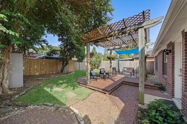 a view of a patio with table and chairs potted plants and a large tree