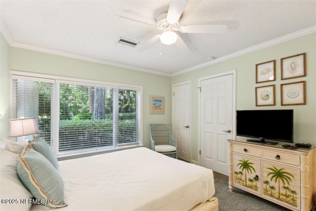 3328 Sea Marsh Road Fernandina Beach, FL 32034 - Photo 20 of 44 a bedroom with a flat screen television and a bed