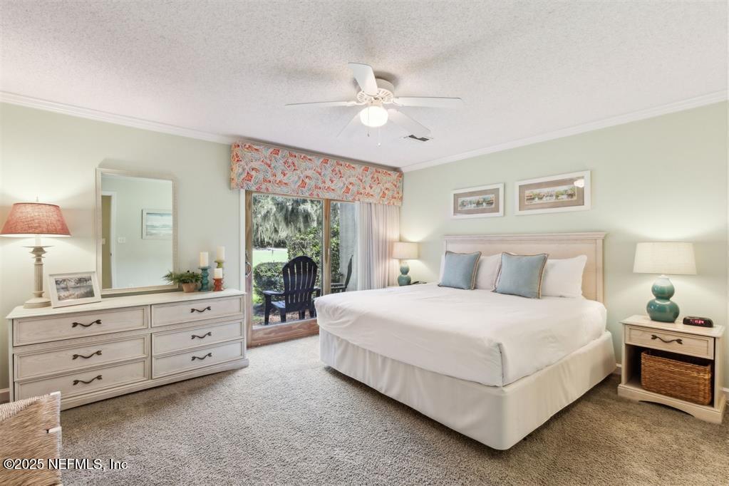 3328 Sea Marsh Road Fernandina Beach, FL 32034 - Photo 23 of 44 a bedroom with a large bed and a chandelier