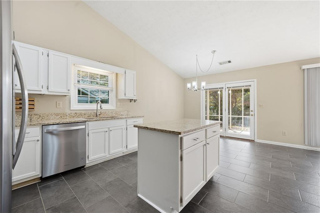 3070 Bugle Drive Duluth, GA 30096 - Photo 14 of 43 a kitchen with granite countertop white cabinets white appliances a sink and a window