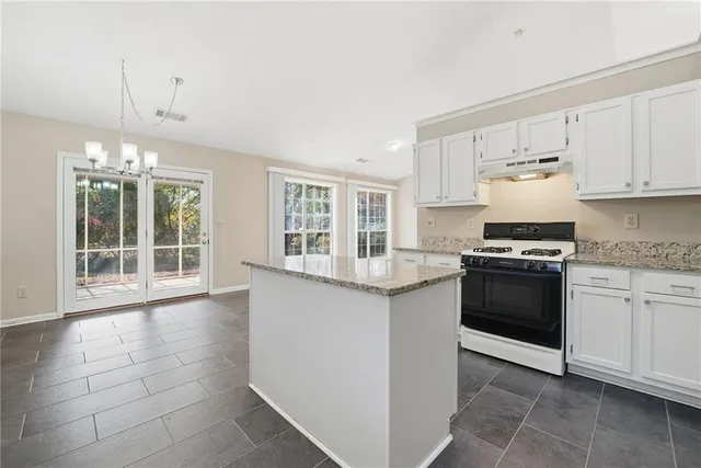 a kitchen with granite countertop white cabinets and appliances