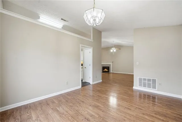 a view of a room with wooden floor and chandelier