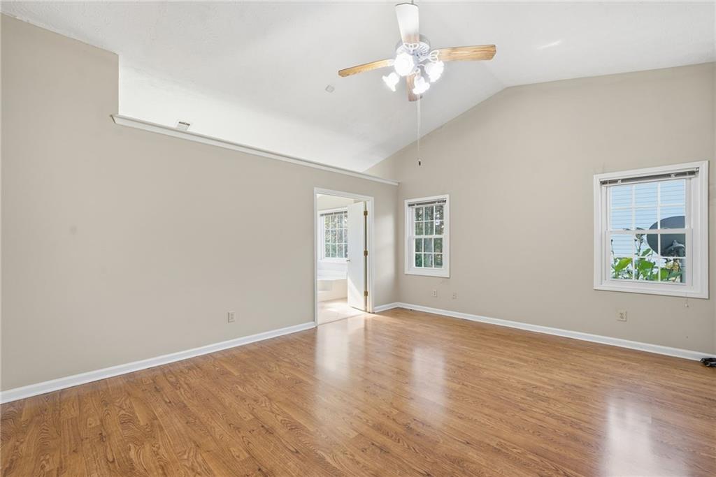 3070 Bugle Drive Duluth, GA 30096 - Photo 20 of 43 an empty room with wooden floor chandelier fan and windows