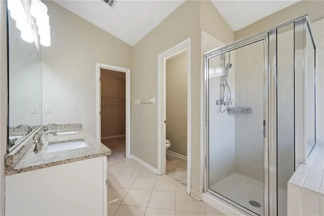 a bathroom with a granite countertop sink mirror and shower
