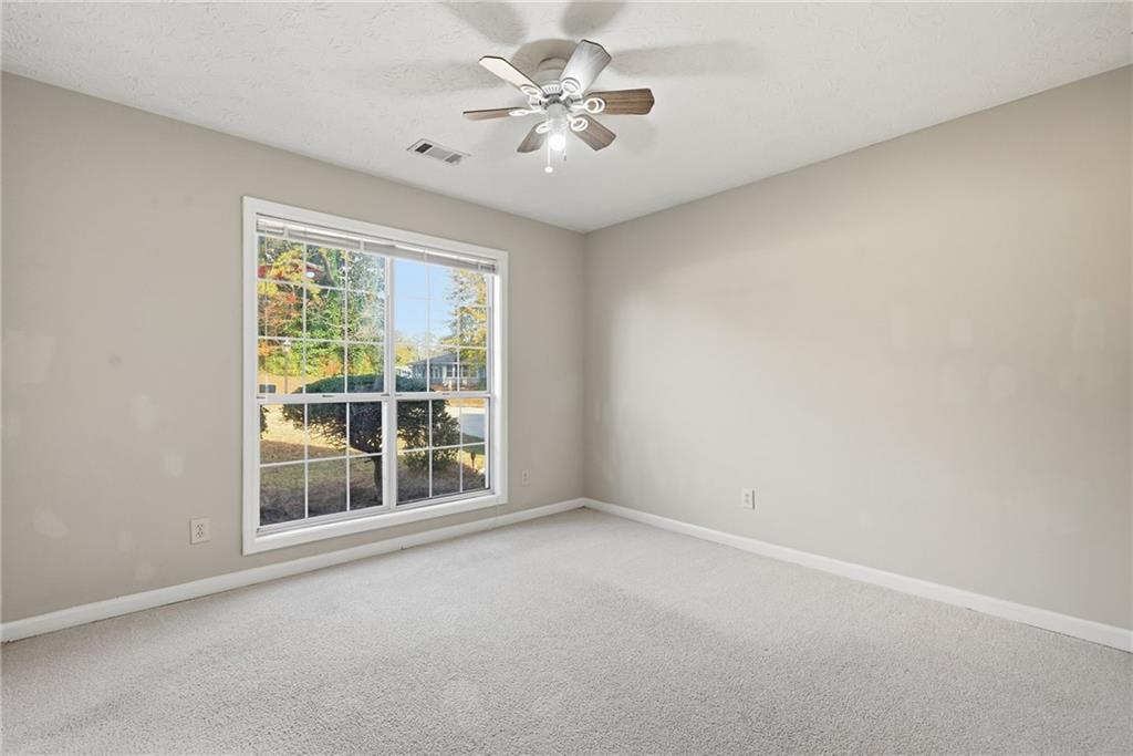 3070 Bugle Drive Duluth, GA 30096 - Photo 27 of 43 an empty room with chandelier fan and windows