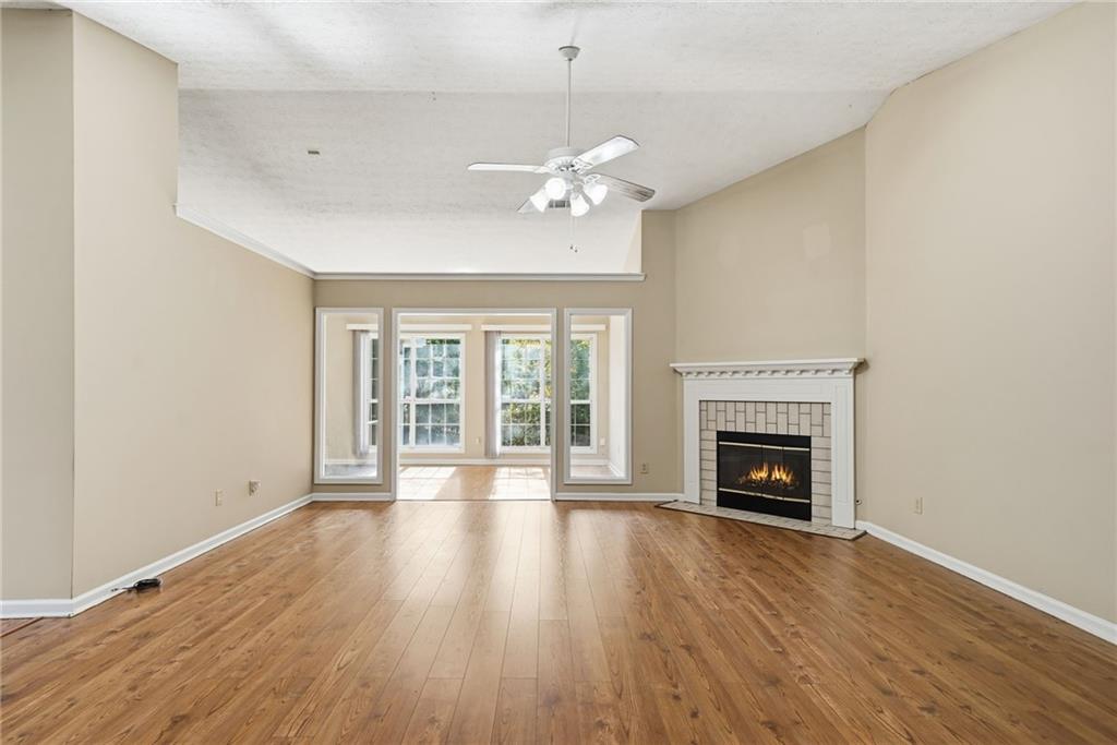3070 Bugle Drive Duluth, GA 30096 - Photo 3 of 43 a view of an empty room with wooden floor fireplace and a window