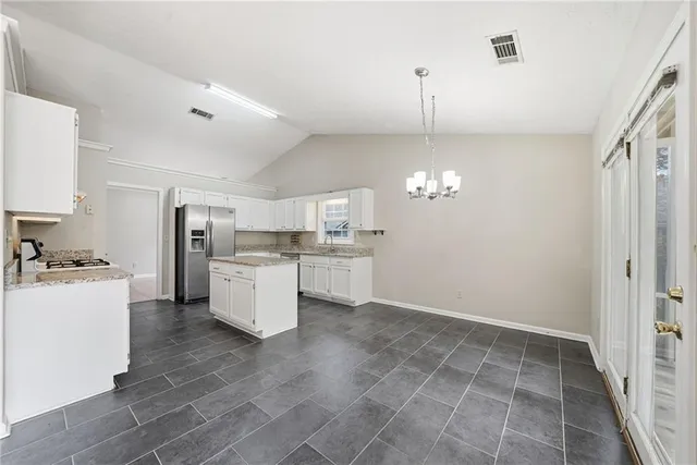 a kitchen with a stove a refrigerator and cabinets