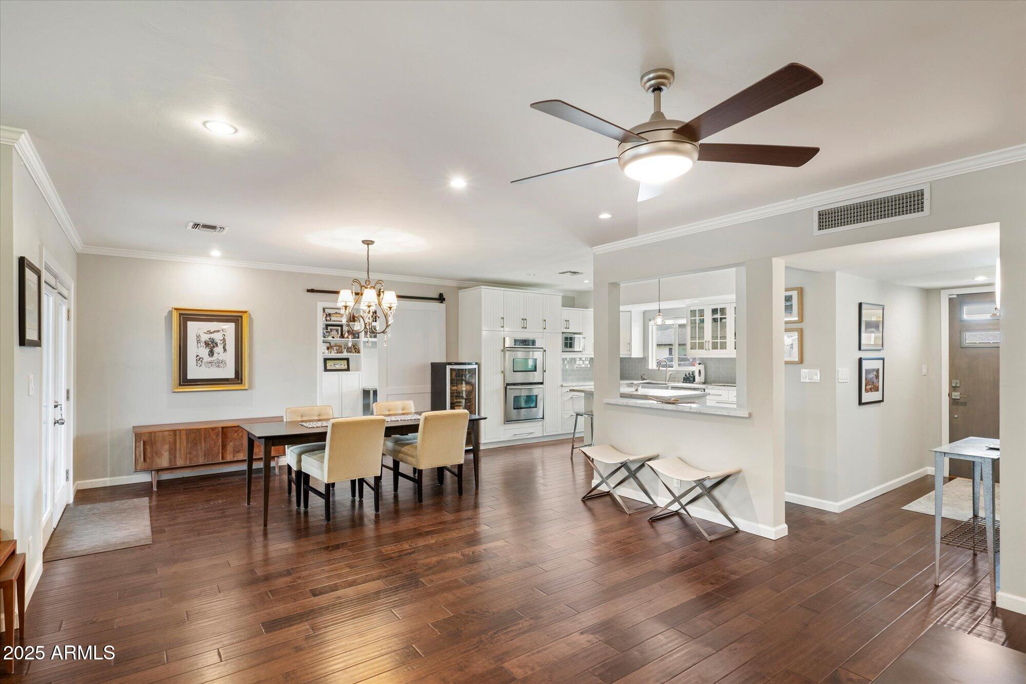3328 East Turney Avenue Phoenix, AZ 85018 - Photo 6 of 35 a view of a dining room and livingroom with furniture wooden floor a ceiling fan and a rug