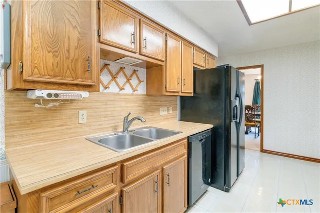 a kitchen with stainless steel appliances granite countertop a sink and a refrigerator