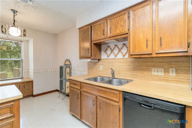 a kitchen with a sink cabinets and window