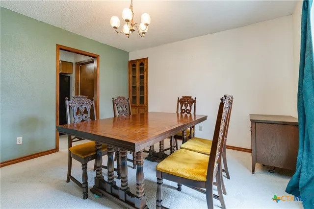 a view of a dining room with furniture and a chandelier