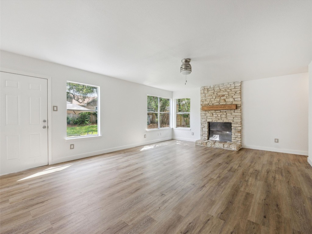 4525 Langtry Lane Austin, TX 78749 - Photo 11 of 31 an empty room with windows fireplace and wooden floor