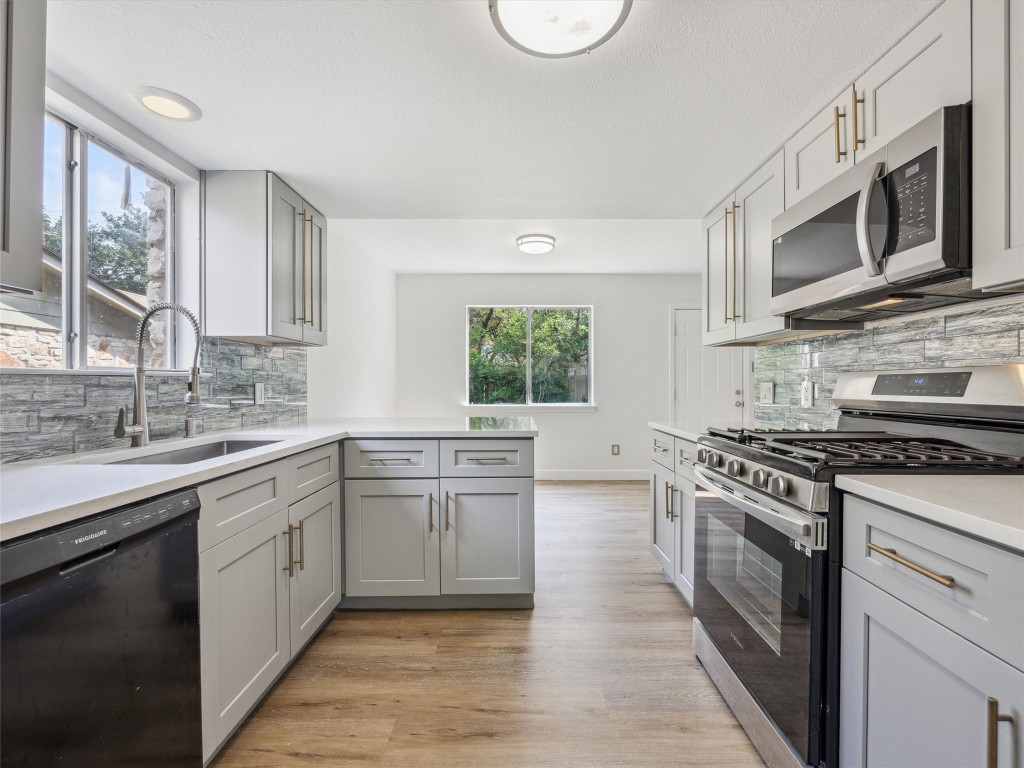 4525 Langtry Lane Austin, TX 78749 - Photo 10 of 31 a kitchen with stainless steel appliances granite countertop a stove a sink and a microwave