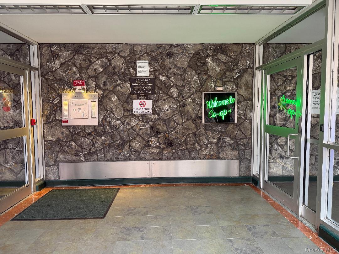 87-56 Francis Lewis Boulevard, Unit A52 Queens, NY 11427 - Photo 2 of 10 a living room with a couch and a floor to ceiling window