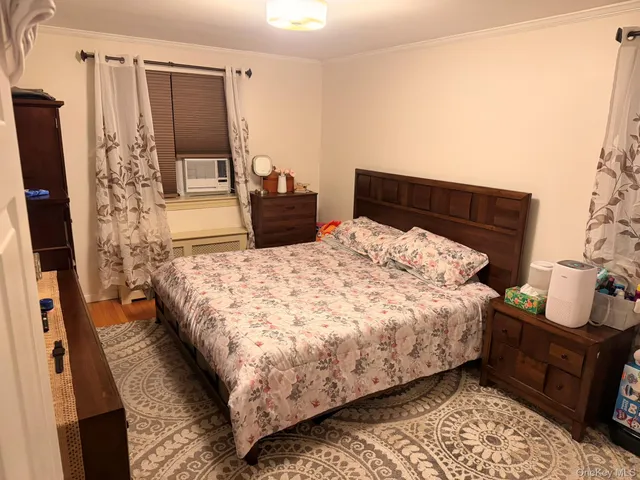a bed sitting in a bedroom next to a window with pc on the table