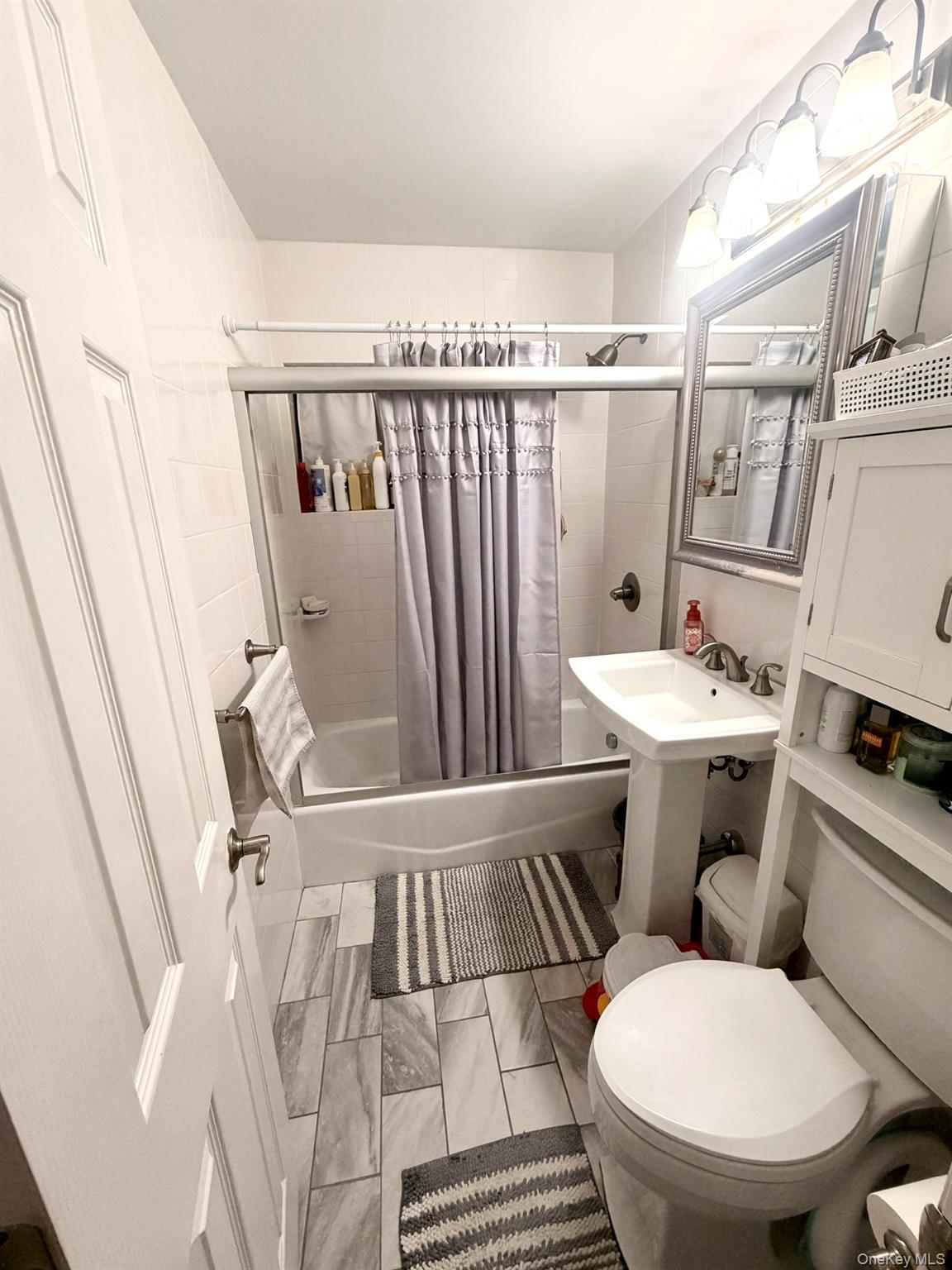 87-56 Francis Lewis Boulevard, Unit A52 Queens, NY 11427 - Photo 7 of 10 a white toilet sitting next to a bathroom sink