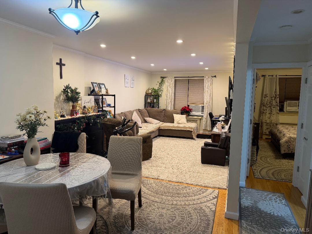 87-56 Francis Lewis Boulevard, Unit A52 Queens, NY 11427 - Photo 10 of 10 a living room with furniture a chandelier and a dining table