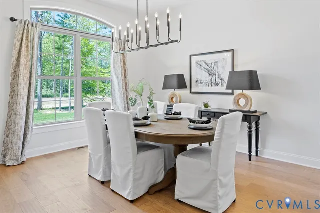 a view of a dining room with furniture a chandelier and wooden floor