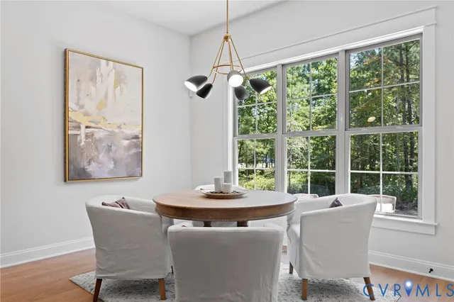 a dining room with furniture a chandelier and wooden floor