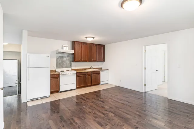 a kitchen with granite countertop a sink stove and refrigerator