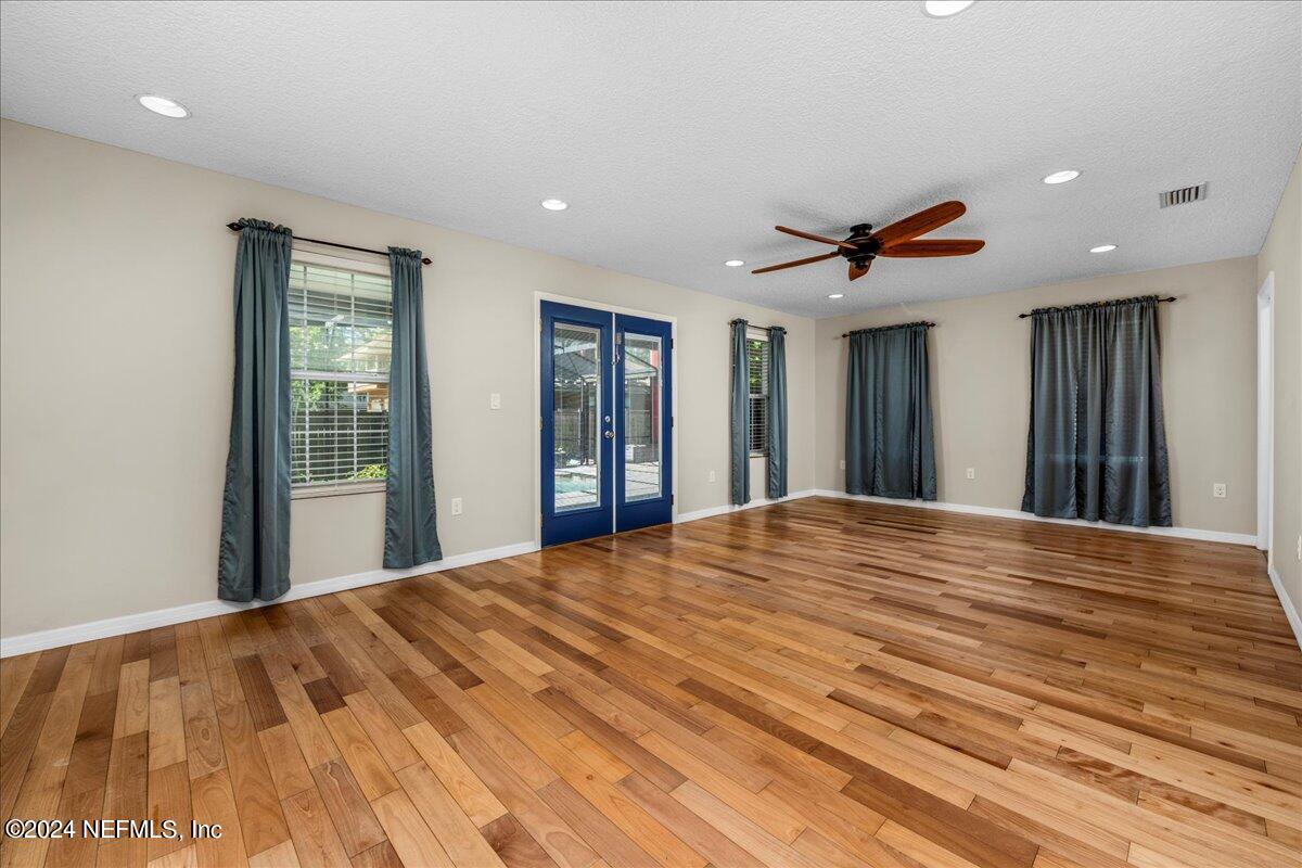 260 Brickyard Road Middleburg, FL 32068 - Photo 16 of 52 a view of a bedroom with wooden floor and a ceiling fan
