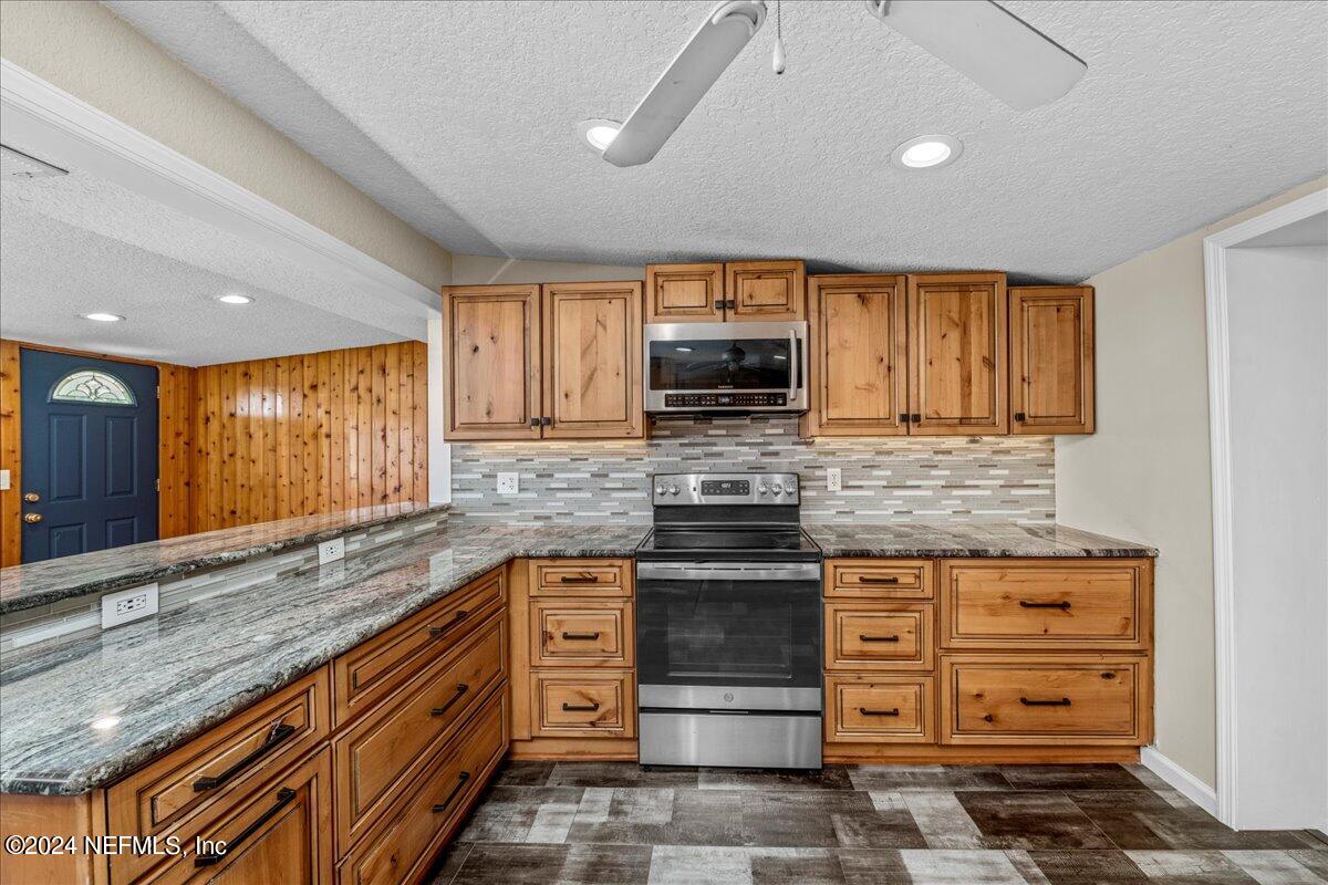 260 Brickyard Road Middleburg, FL 32068 - Photo 20 of 52 a kitchen with stainless steel appliances granite countertop a stove a sink and a microwave