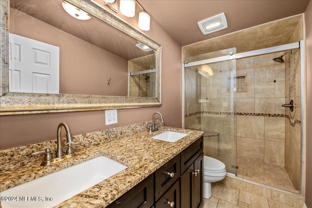 260 Brickyard Road Middleburg, FL 32068 - Photo 27 of 52 a bathroom with a granite countertop sink a toilet a mirror and shower
