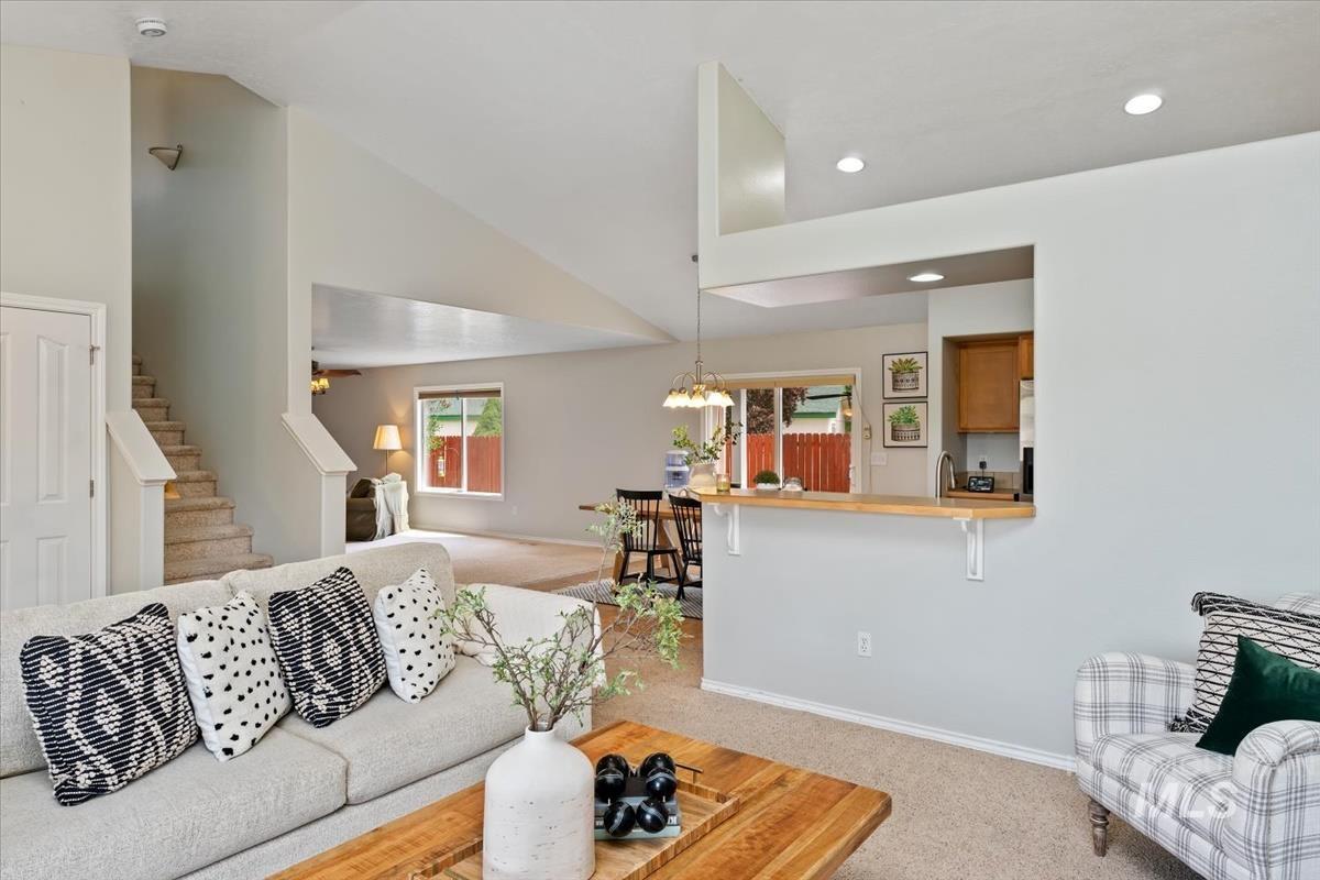 80 Cobblestone Court Middleton, ID 83644 - Photo 5 of 48 Living area with vaulted ceilings, recessed lighting, carpet flooring, a pass-through breakfast bar, and staircase access