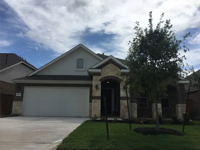 a front view of a house with a garden and trees