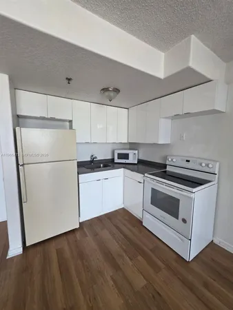a kitchen with a refrigerator stove and white cabinets