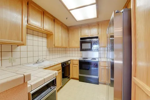a kitchen with a sink stainless steel appliances and cabinets