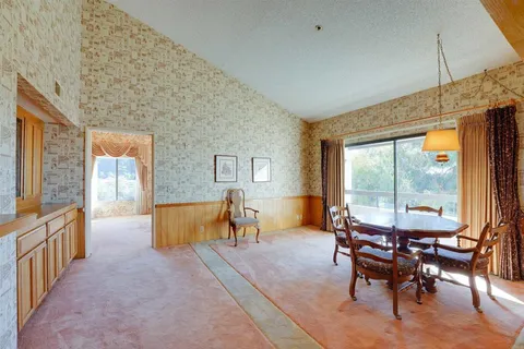 a dining room with furniture and a floor to ceiling window