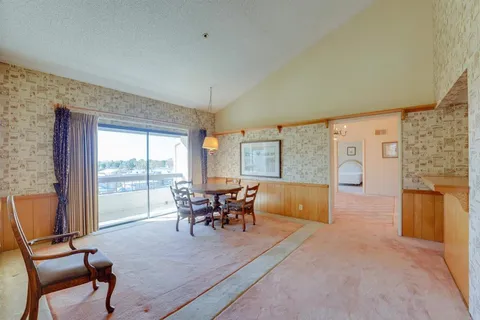 a dining room with furniture and large windows