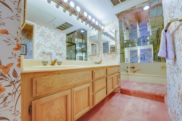 a spacious bathroom with a sink a mirror and a bathtub
