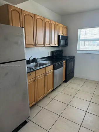 a kitchen with stainless steel appliances granite countertop a refrigerator sink and stove